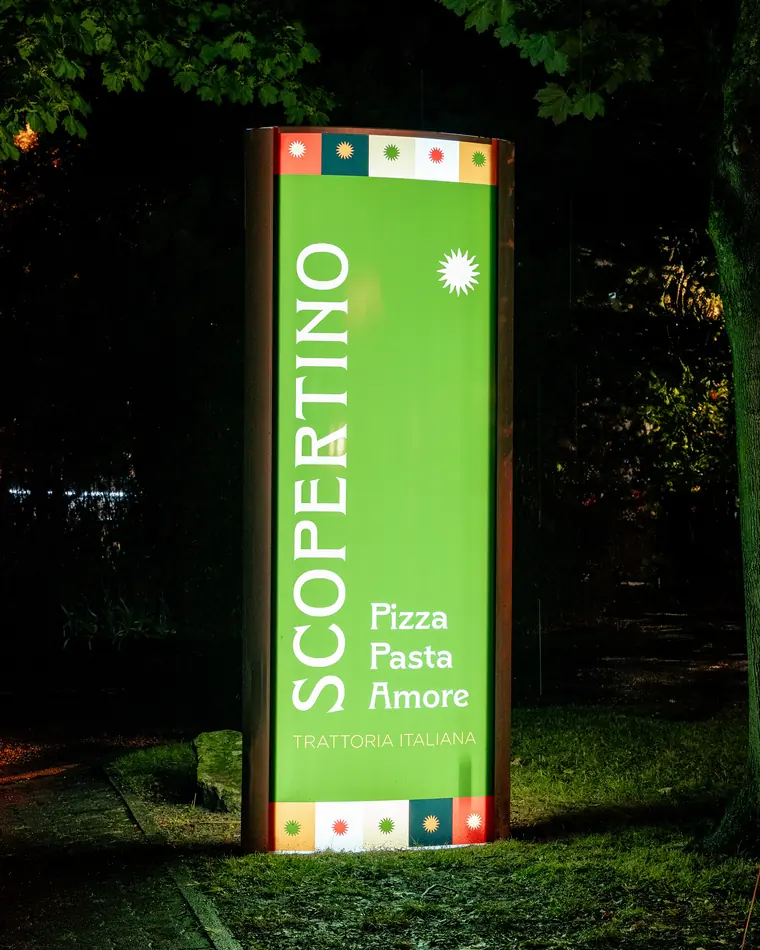 Totem lumineux Scopertino « Pizza Pasta Amore » allumé la nuit dans le jardin